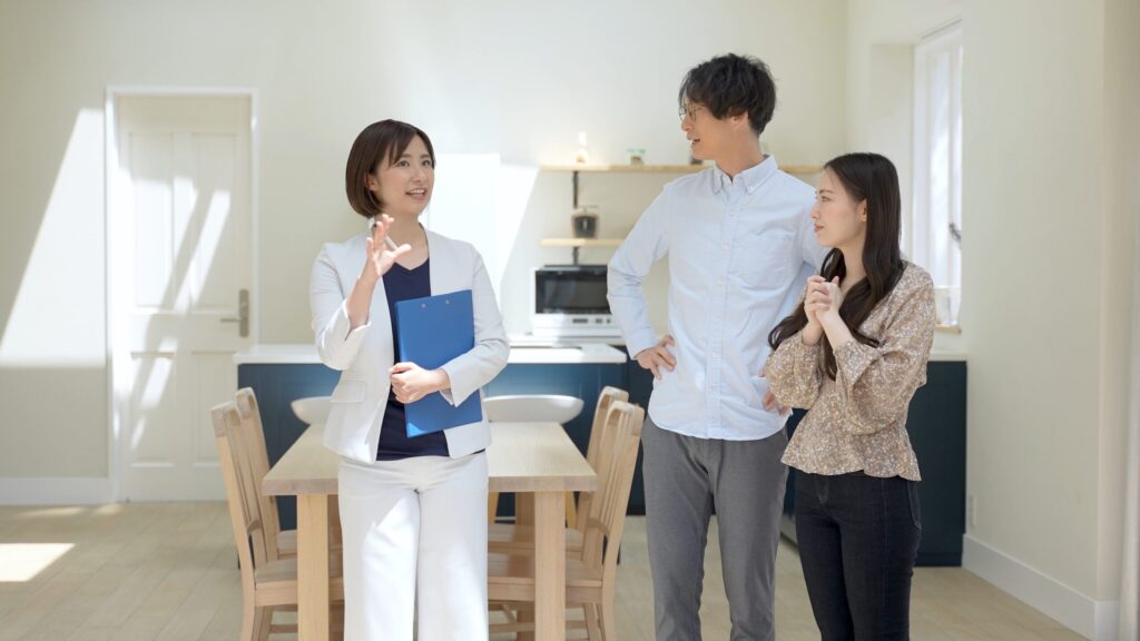完成した住まいのダイニングで、担当者が資料を手に見学のご夫婦へ説明している